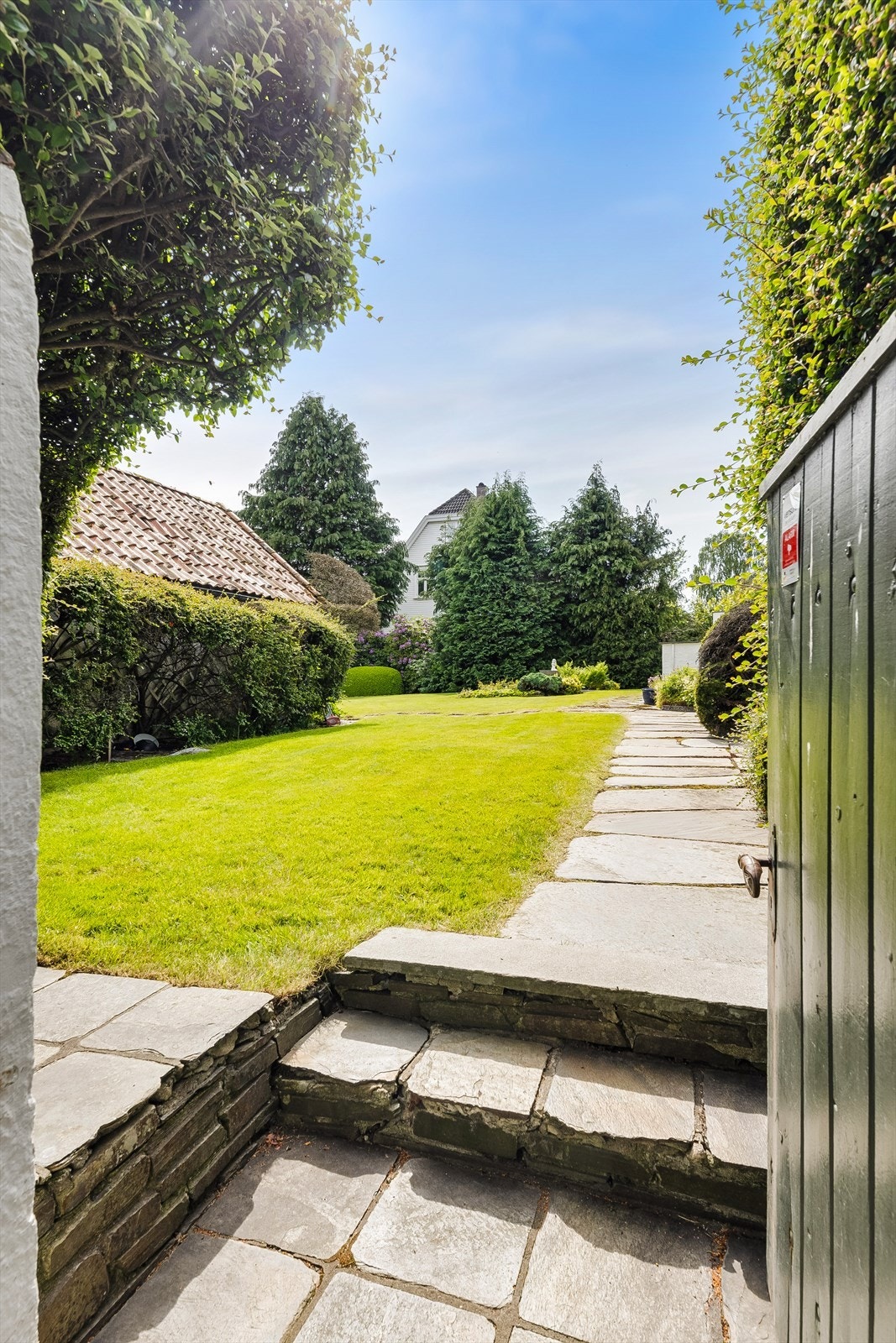 En sjarmerende port leder fra innkjørselen og inn i den private hagen. Galleribilde