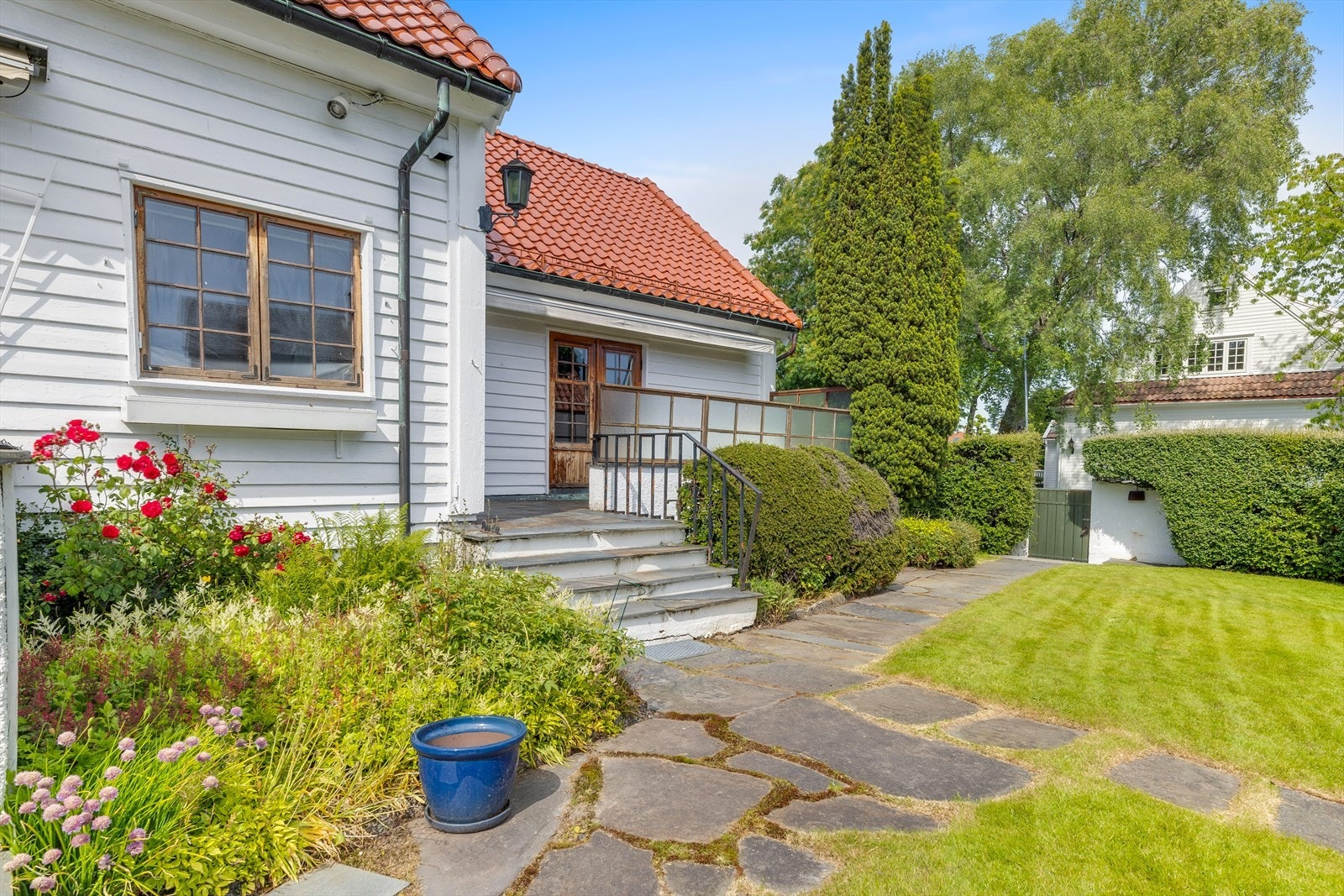 Sideinngang med trapp i skifer og blomstrende beplantning. Galleribilde