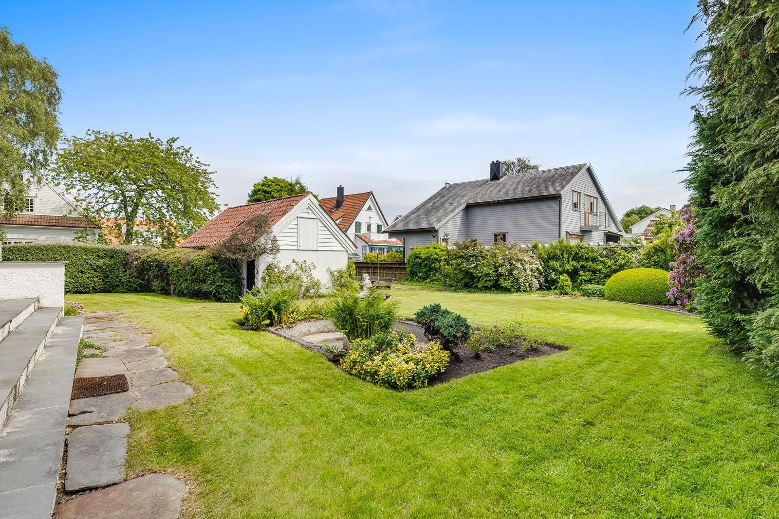 Hagen er pent opparbeidet med store plenarealer og etablert beplantning. Galleribilde