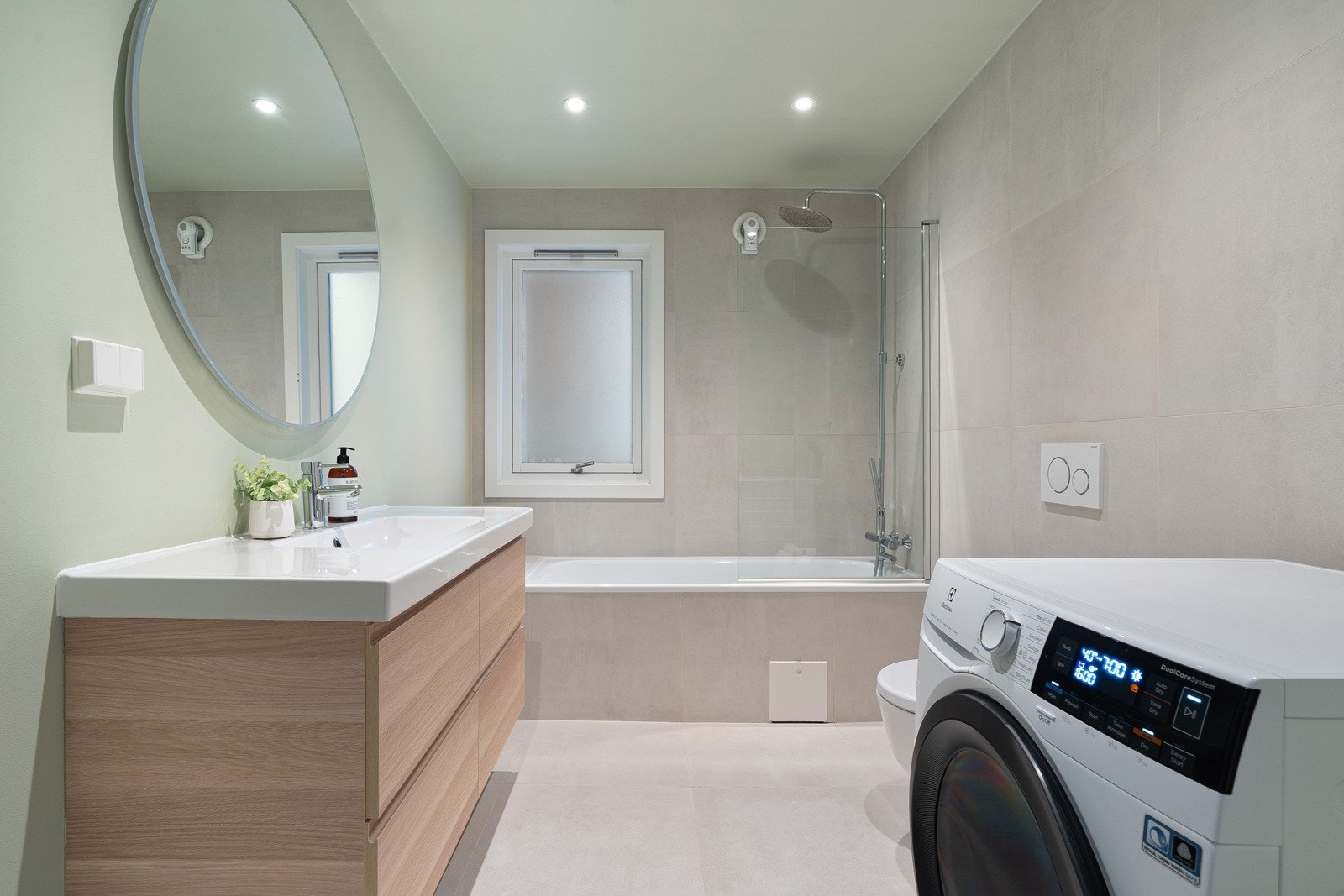 Delikat bad med badekar, downlights i himling og moderne innredning.