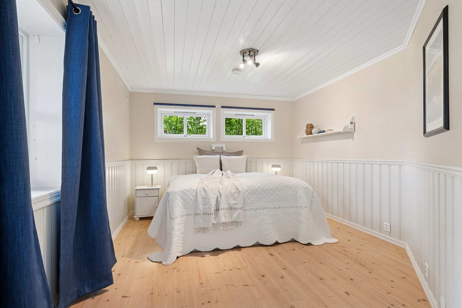 Romslig soverom med plass til seng, nattbord og oppbevaring Galleribilde