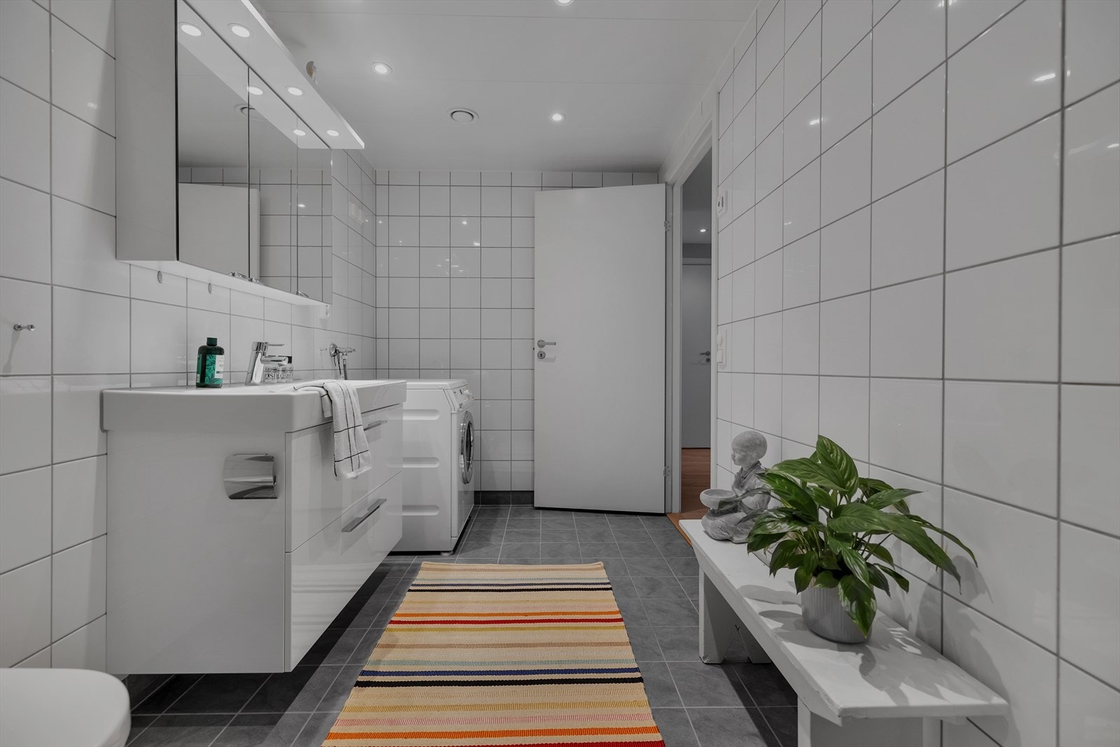 Rommet har innredning med nedfelt servant, veggmontert toalett,
dusjvegger/hjørne og opplegg for vaskemaskin. Speilskap med lys
over. Galleribilde