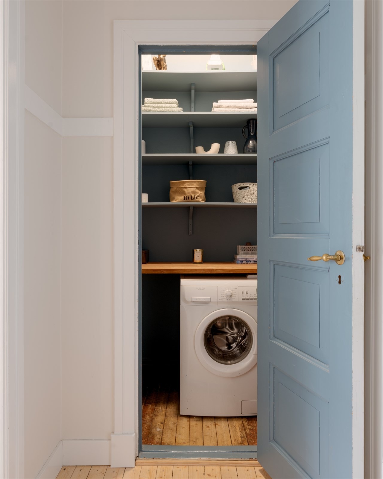 Praktisk innvendig bod med plassbygde hyller for oppbevaring og opplegg for vaskemaskin. Galleribilde