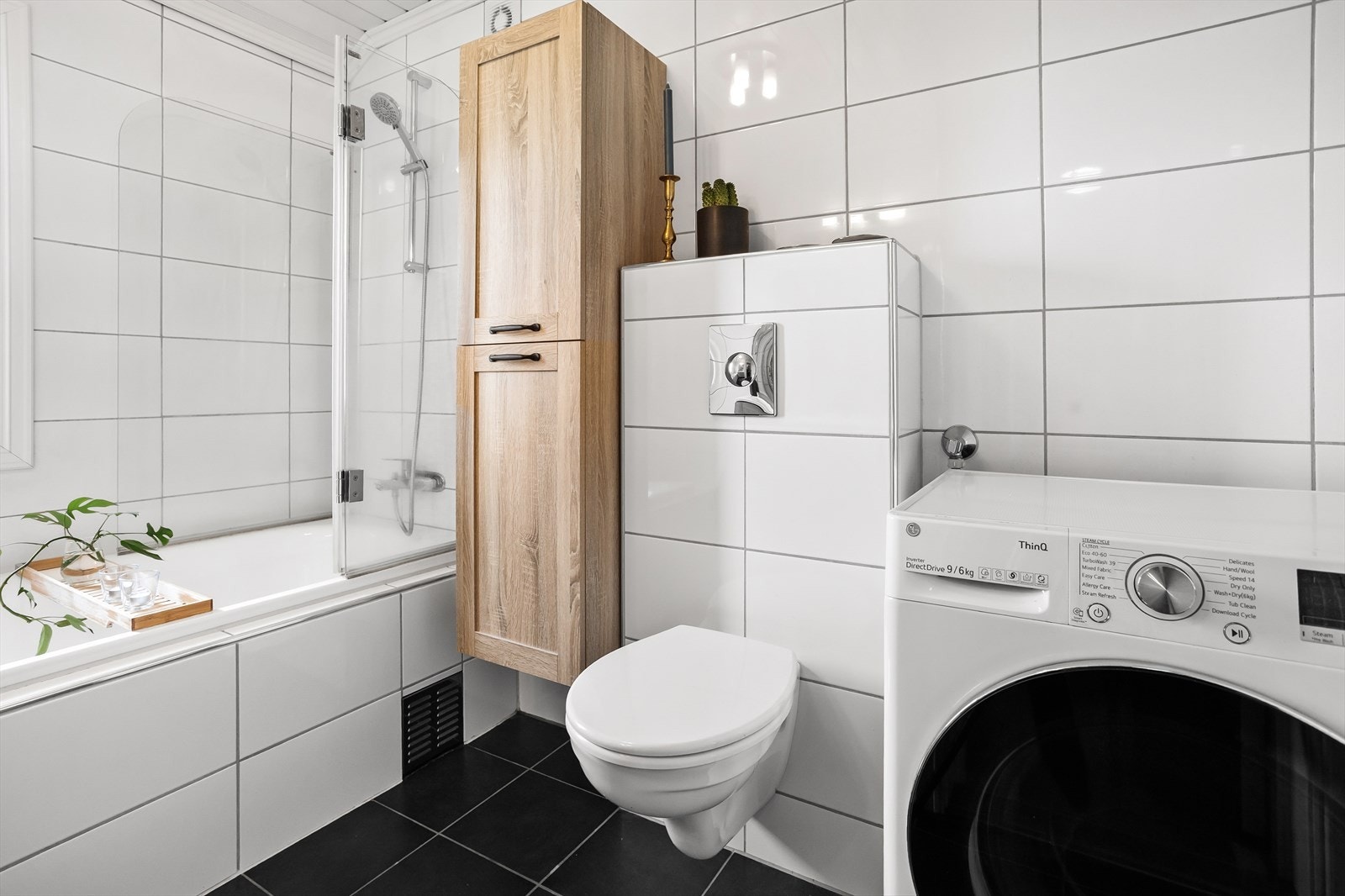 Flislagt bad med mørke gulvfliser som står i flott kontrast til de lyse veggflisene. Varmekabler i gulv. Galleribilde