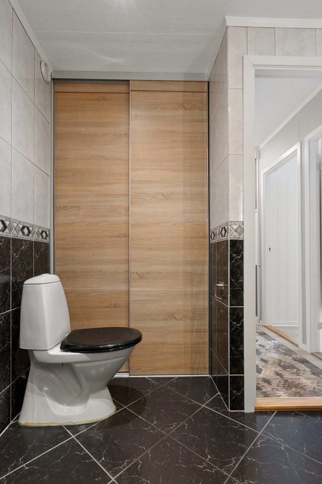 Badet byr videre på rikelig med oppbevaring i flere skap, romslig dusjkabinett, toalett og servant med skuffer. Galleribilde