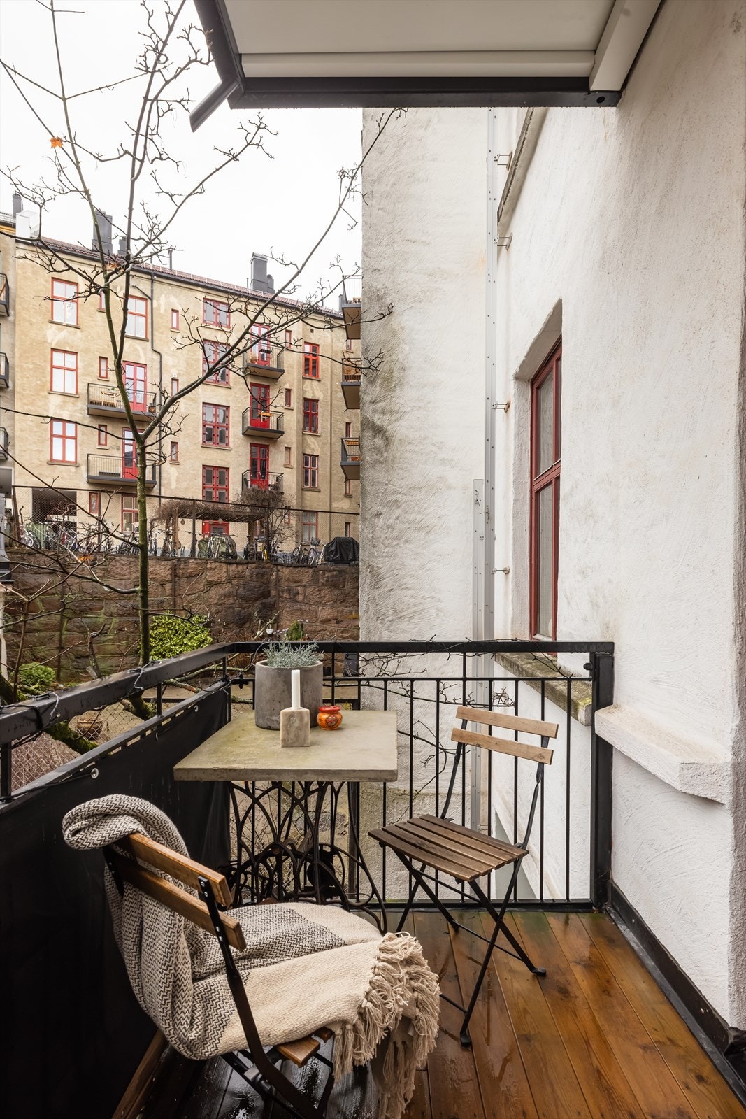 Balkongen har terrassebord på gulvet og et rekkverk av metall. Galleribilde