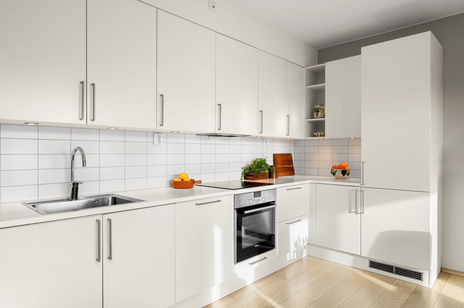 Det er mye lagringsplass i over-og underskap, spotbelysning over kjøkkenbenk og flere stikkontakter under innredning. Galleribilde