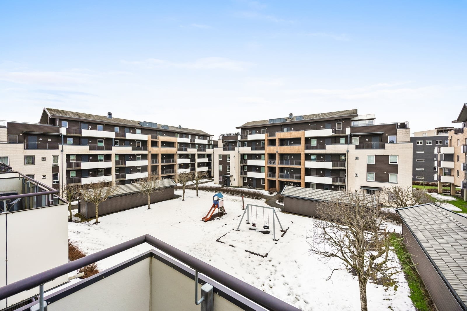 Balkongen er vendt ut mot fellesarealet med lekeplass og grøntområde. Galleribilde