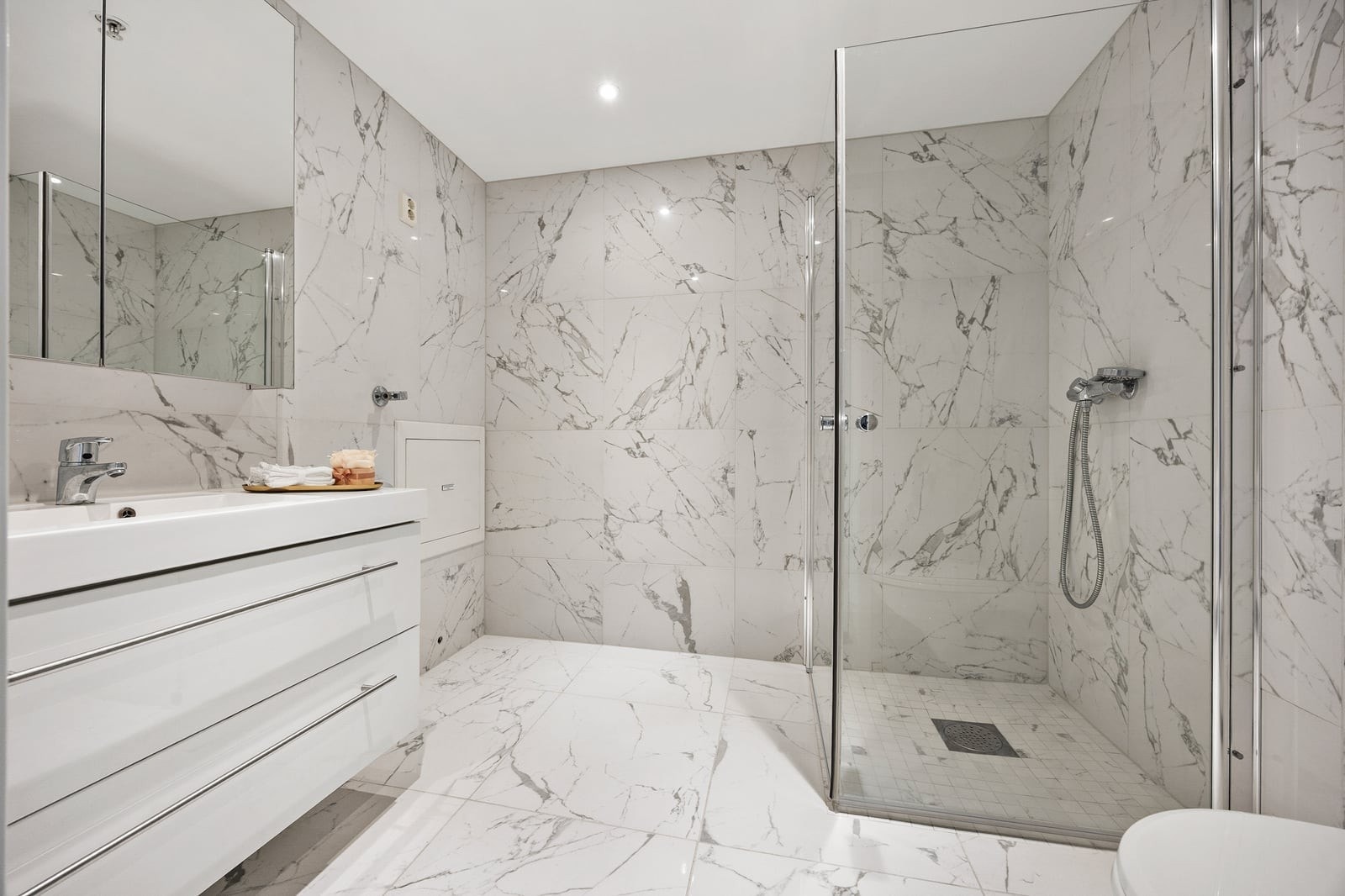 Pent flislagt baderom med gulvvarme og downlights. Galleribilde