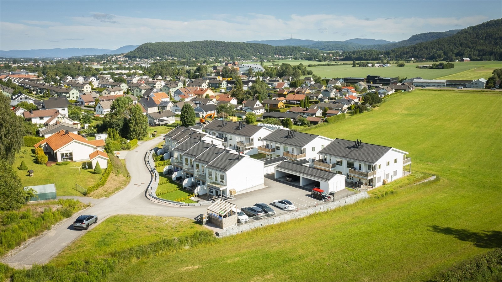 Det er markerte bil oppstillingsplasser til høyre for rekkehusene. Galleribilde