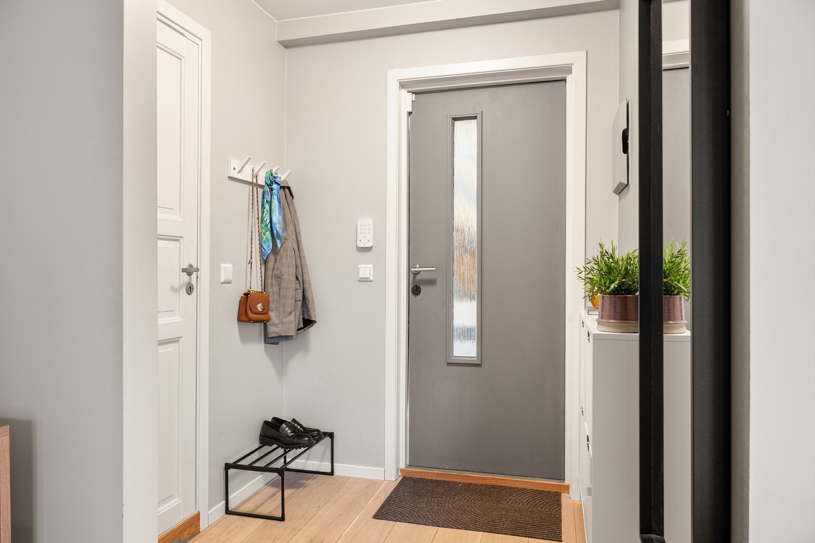 Innbydende entré med gode oppbevaringsmuligheter og naturlig flyt videre inn i boligen Galleribilde