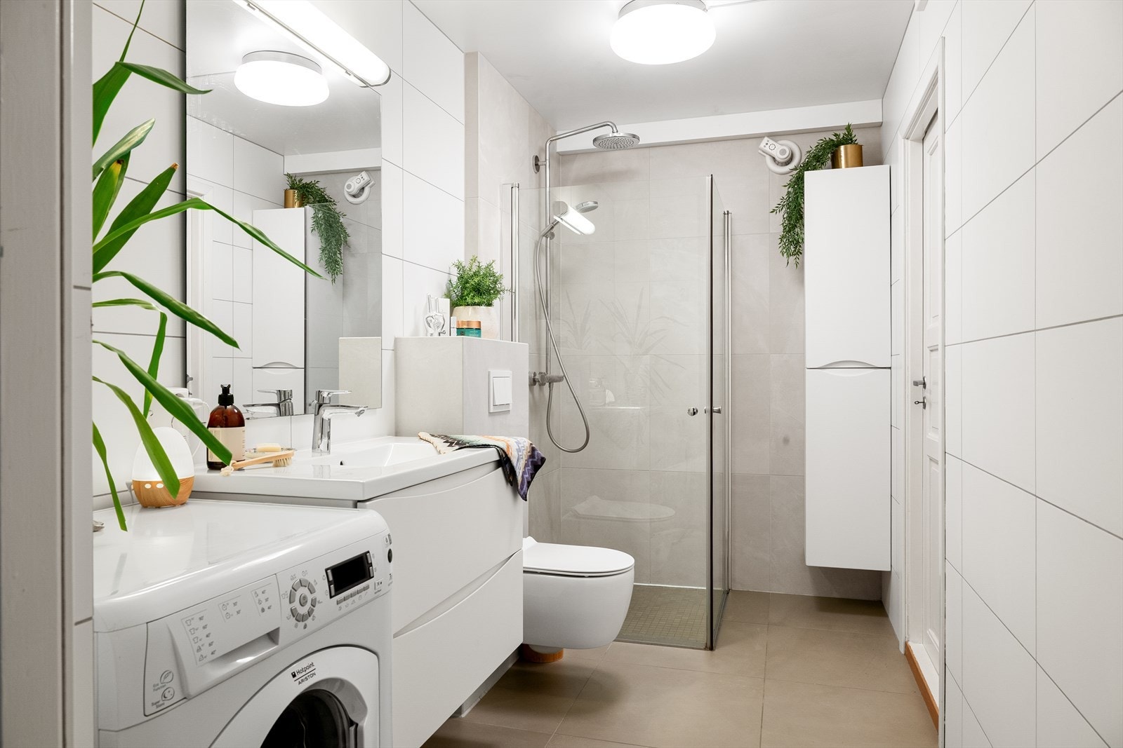 Praktisk baderom med opplegg for vaskemaskin og god plass til oppbevaring i høyskap. Galleribilde