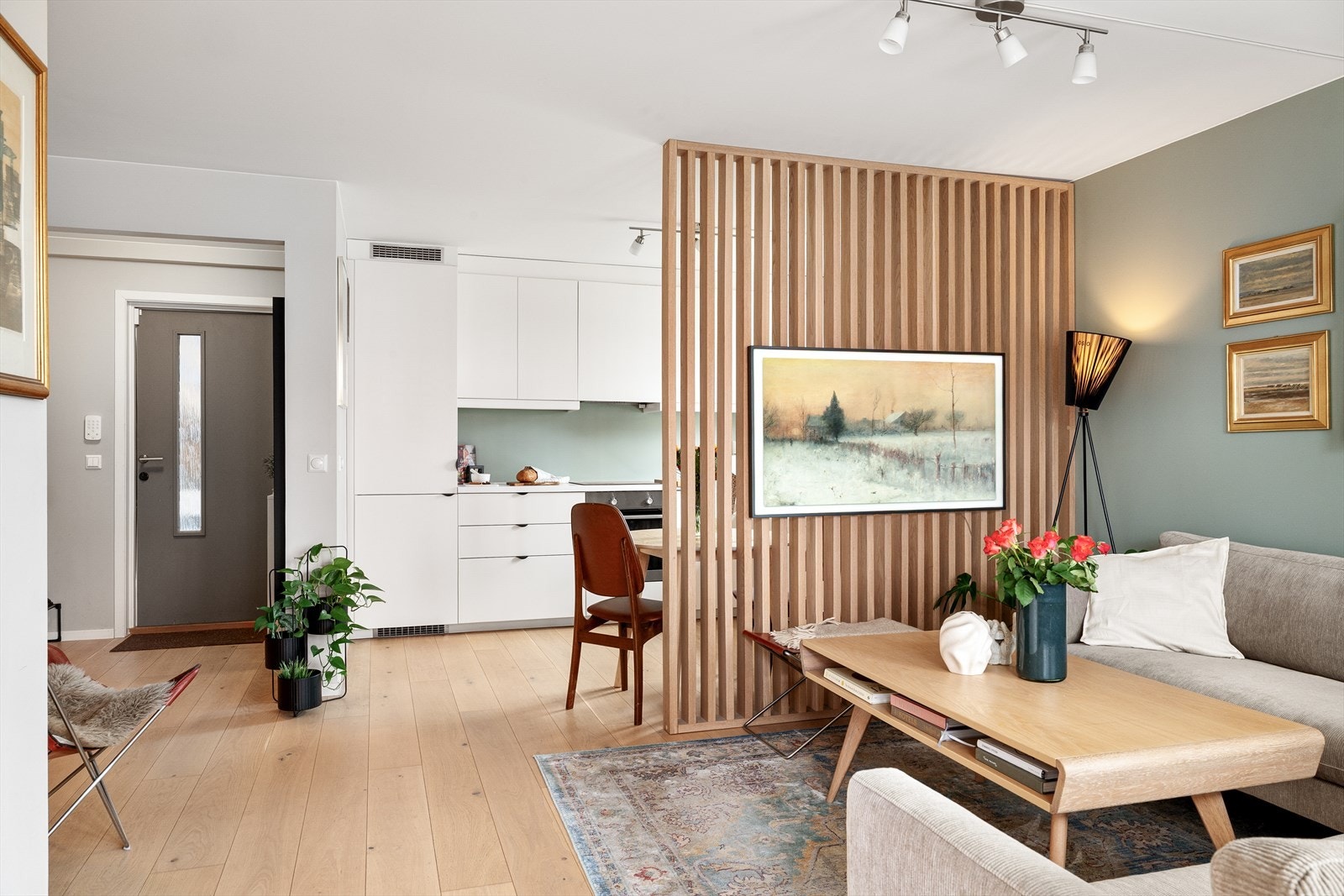 Lys og tiltalende oppholdsdel med åpen løsning mot kjøkkenet. Spileveggen gir rommet et moderne preg og bidrar til en naturlig soneinndeling. Galleribilde