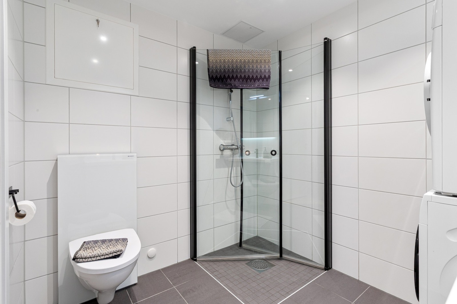 Badet er praktisk utstyrt med blant annet innfellbare dusjvegger og vegghengt toalett. Galleribilde