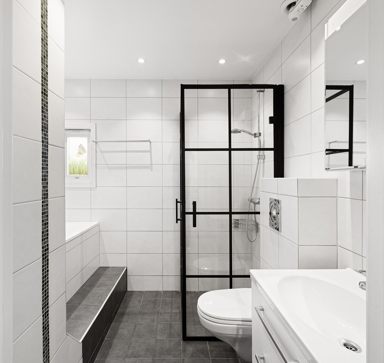 Lekkert bad med moderne uttrykk, flislagte overflater og behagelig gulvvarme. Galleribilde