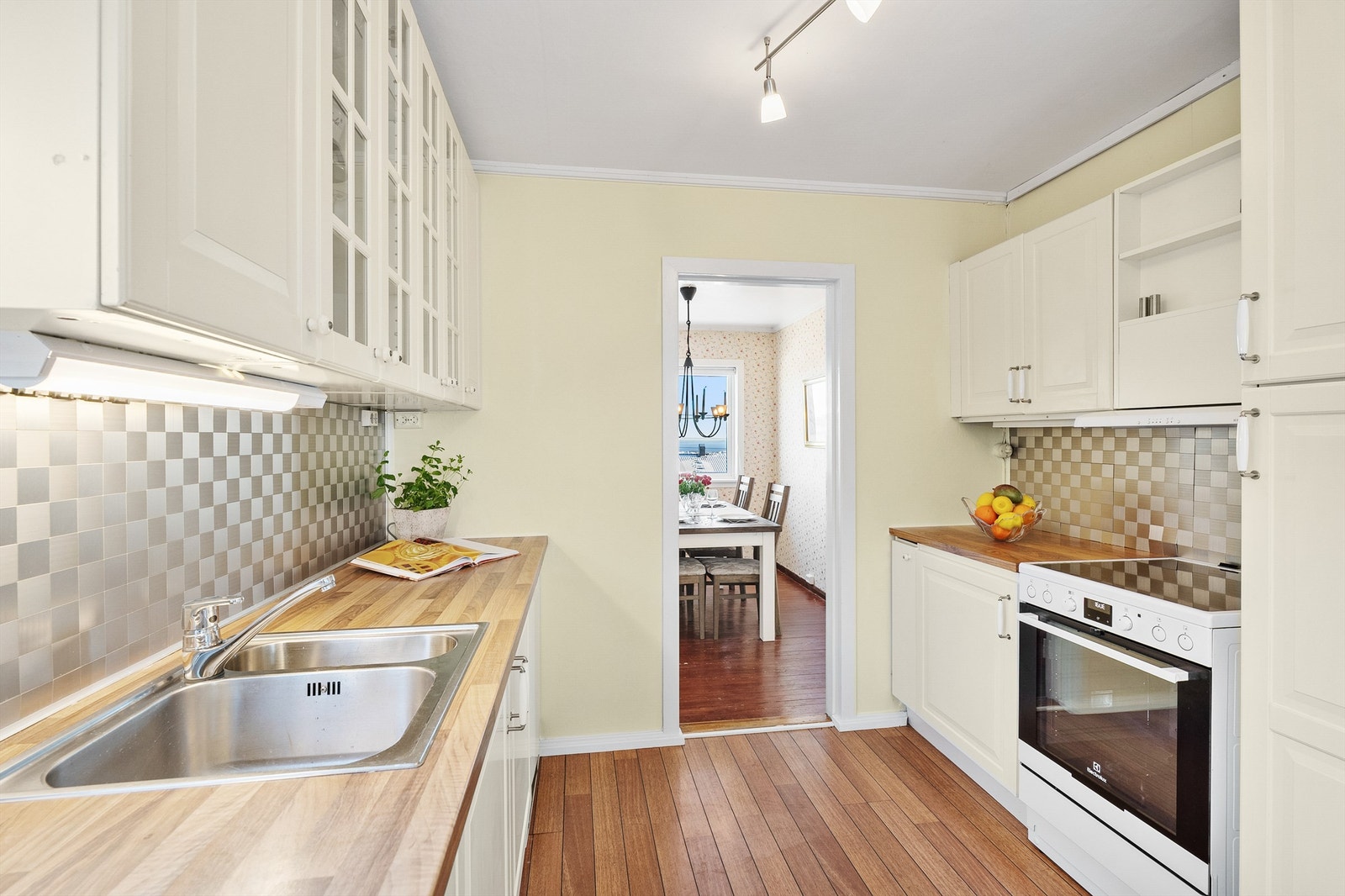 Kjøkkeninnredning med lyse, profilerte fronter og laminert benkeplate Galleribilde