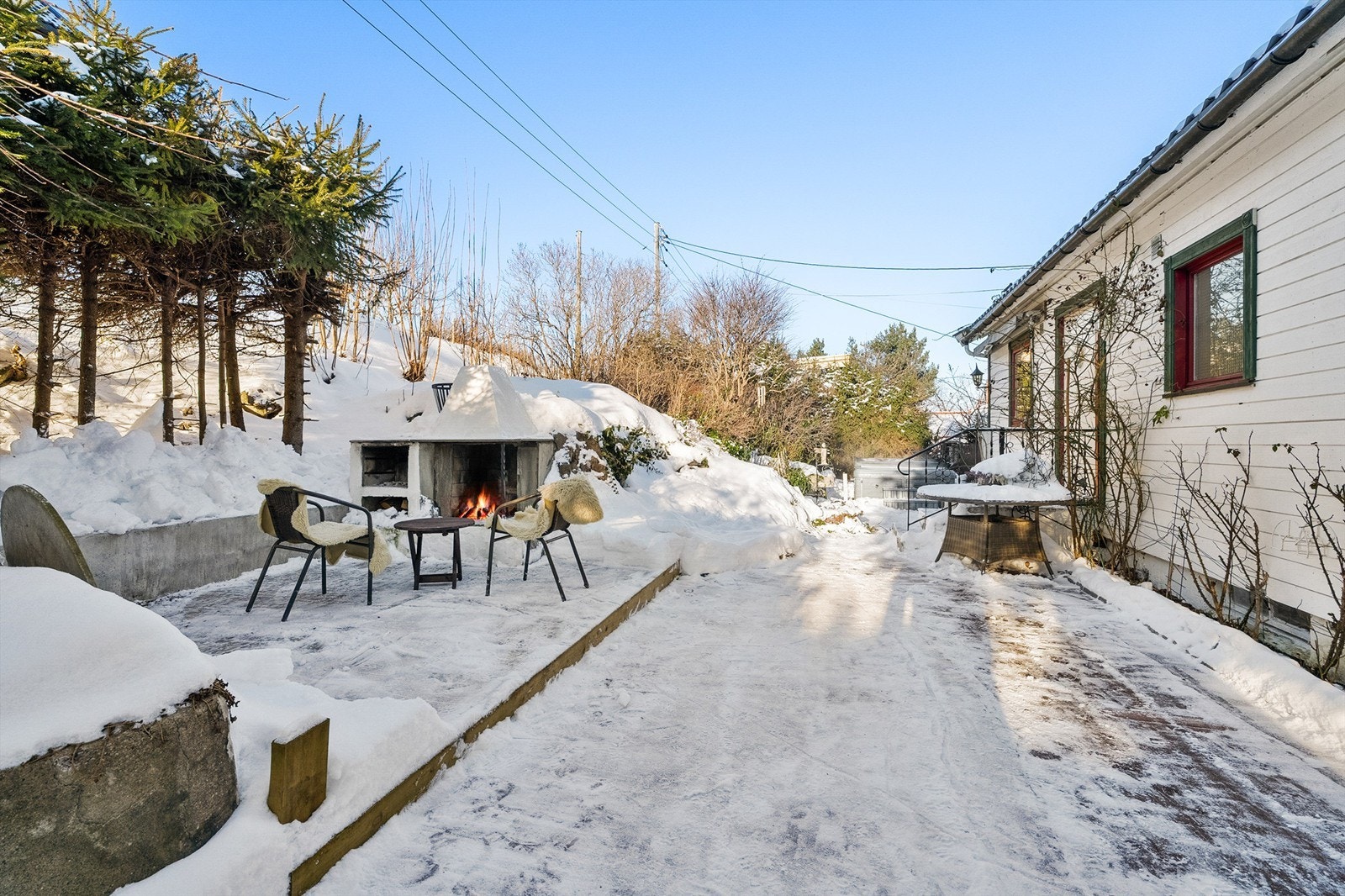 Flott uteplass på terrasseplatting med peis. God plass til utemøbler Galleribilde