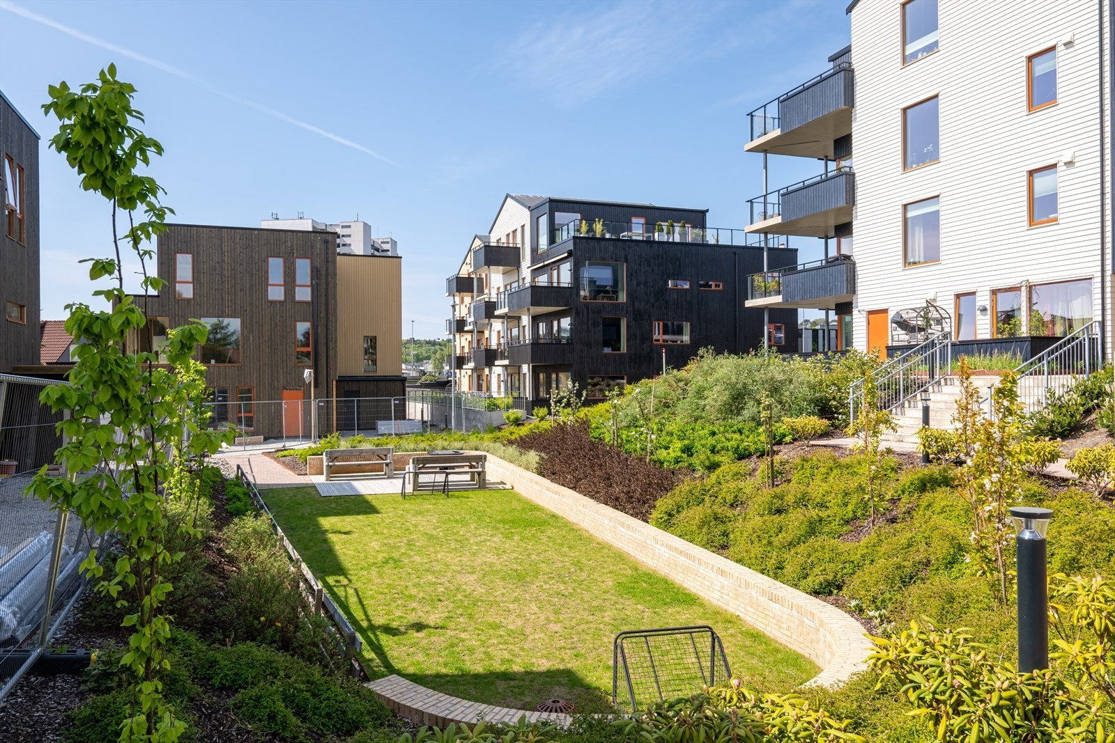 Flotte felles uteområder pent opparbeidet med lekeplasser, sittegrupper, grøntområder, plen og annen beplantning. Galleribilde