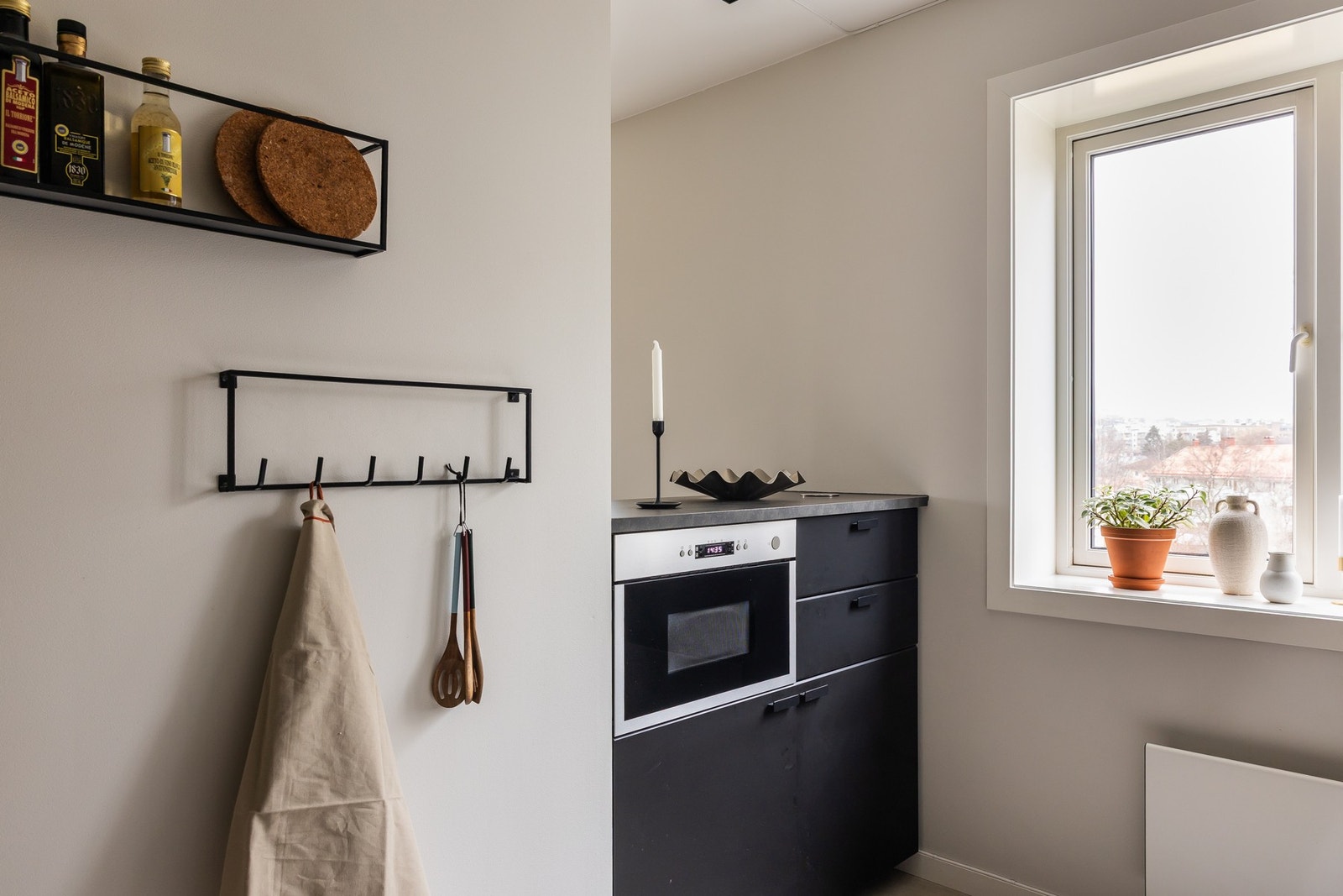 Sorte, glatte fronter og integrerte hvitevarer som oppvaskmaskin, stekeovn og koketopp samt mikroovn. Galleribilde