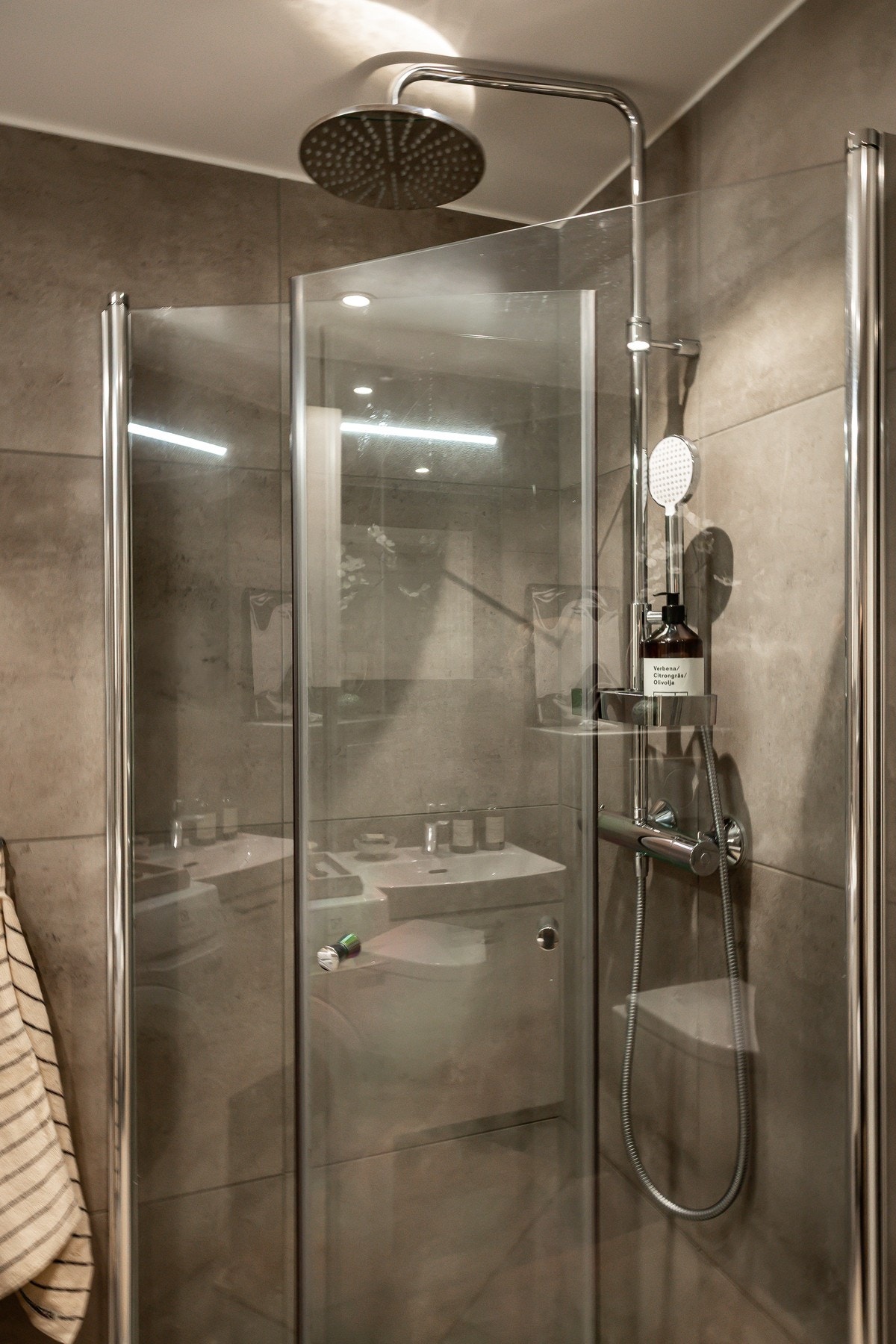 Badet er innredet med dusj med innfellbare dusjdører, vegghengt klosett og servant med servantskap. Galleribilde