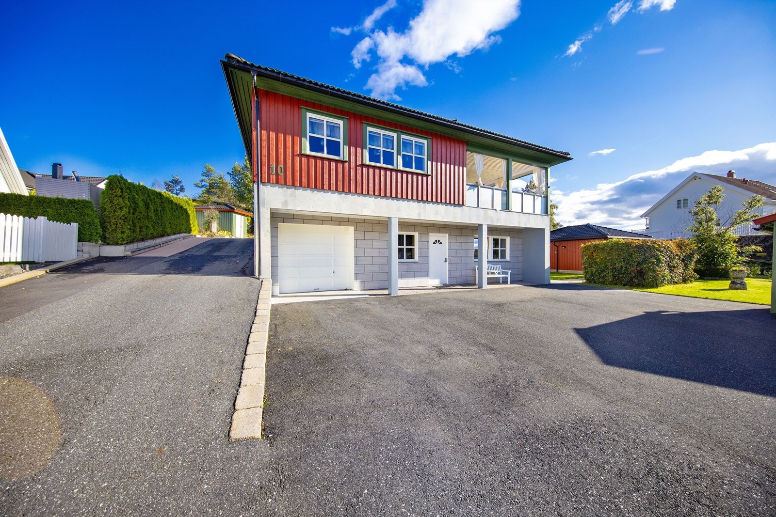 Flis er benyttet i stor utstrekning inne i boligen, men også grunnmuren er flislagt. Garasjen til høyre har port med elektrisk åpner og bod i bakkant. Galleribilde