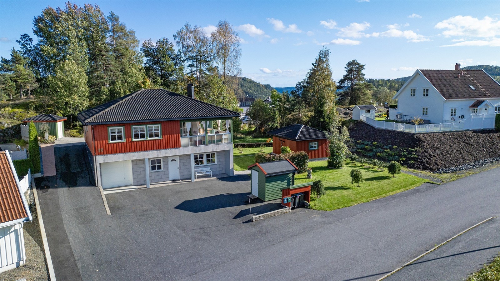 Tomten er pent opparbeidet og beplantet, asfaltert gårdsplass. Galleribilde