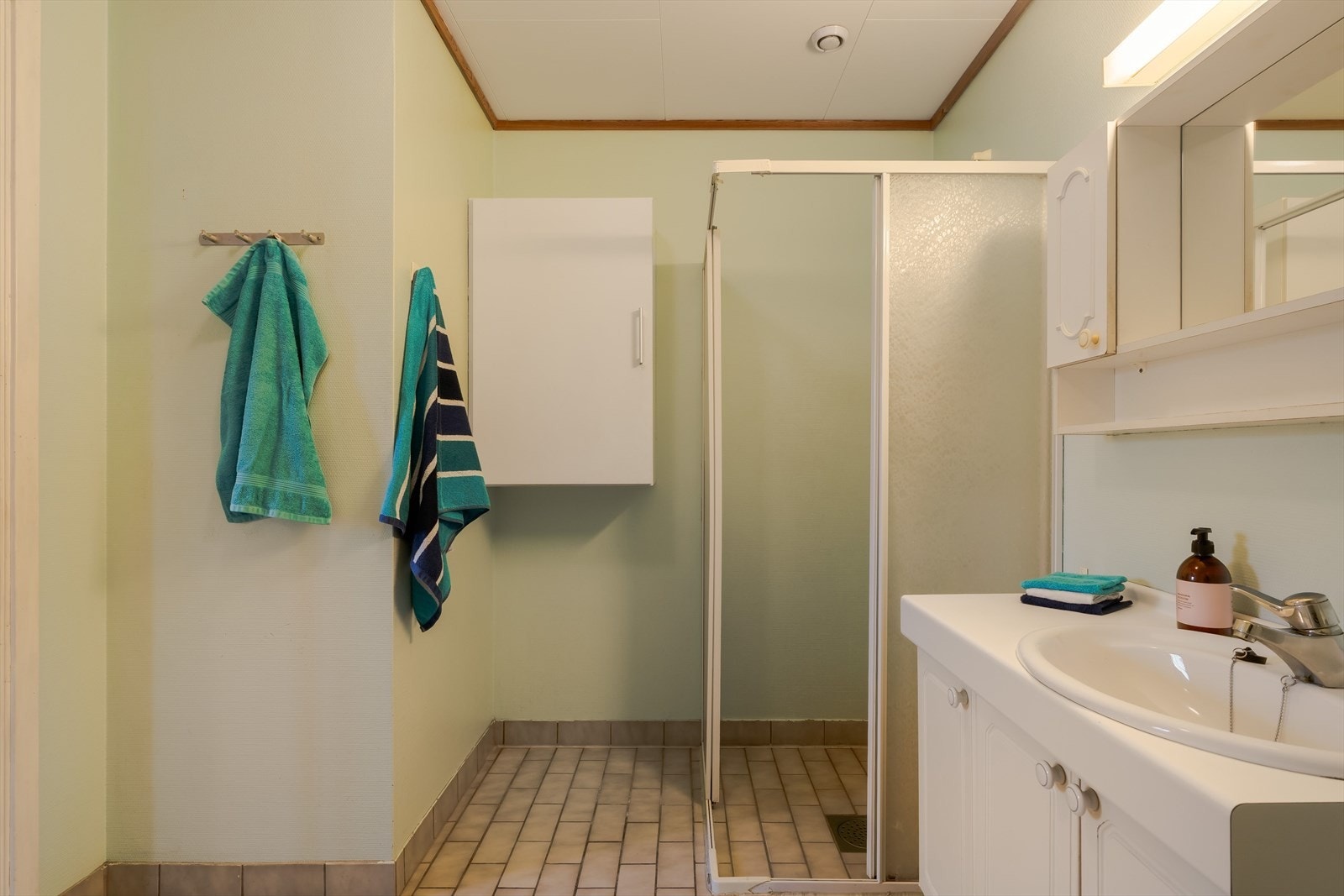 Stort bad med opplegg for vaskemaskin, dusjhjørne og WC. Galleribilde