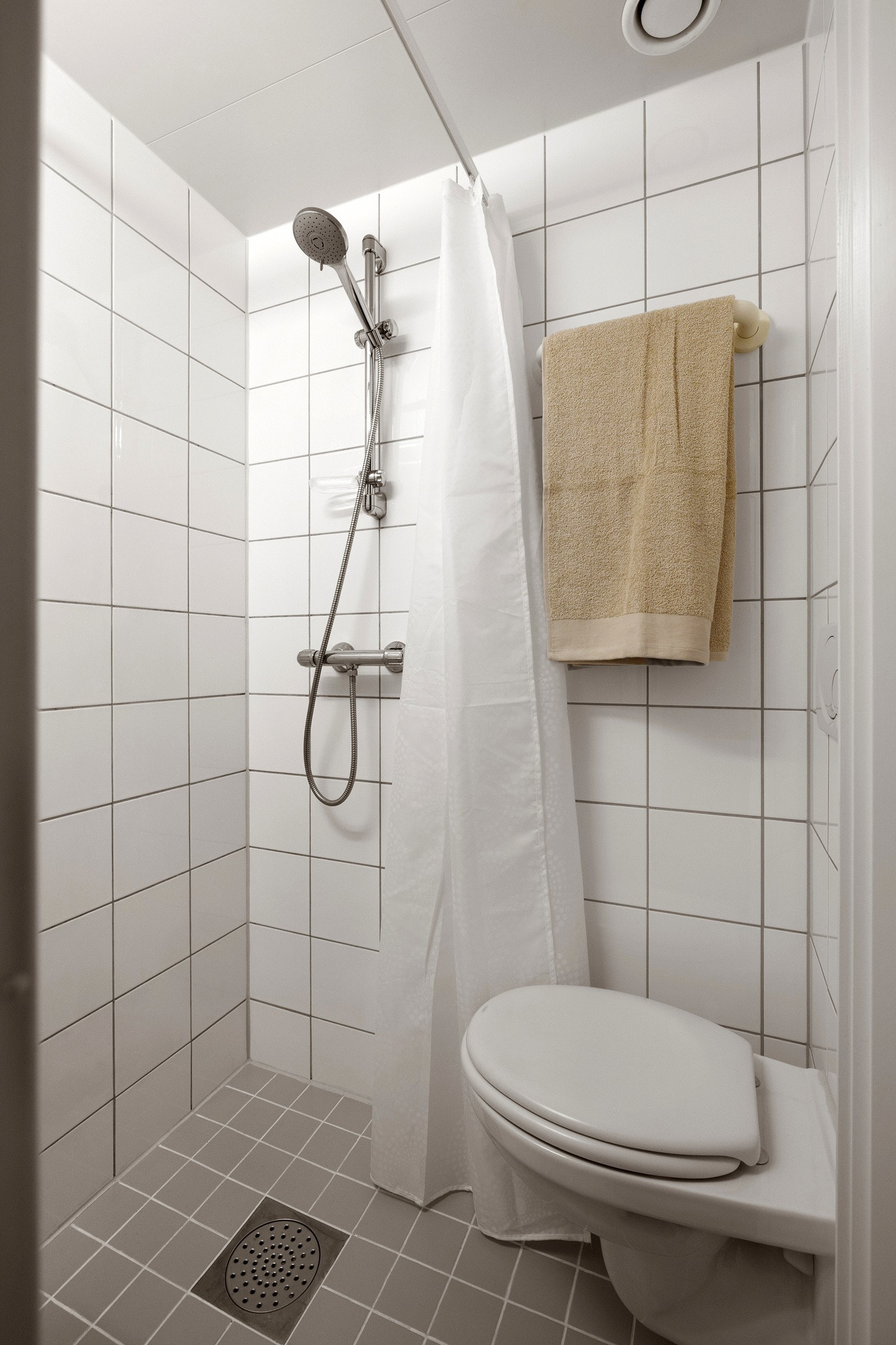 Flislagt baderom med nøytrale farger og varmekabler på gulvet. Galleribilde