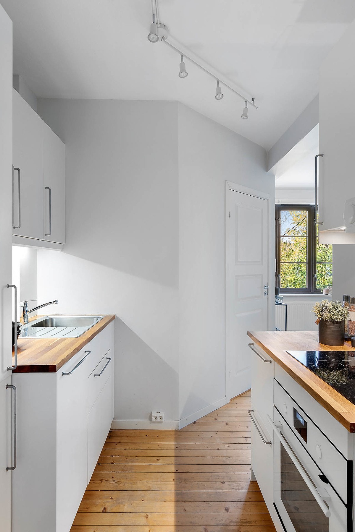 Lyst kjøkkeninnredning fra Ikea med integrerte hvitevarer. Galleribilde