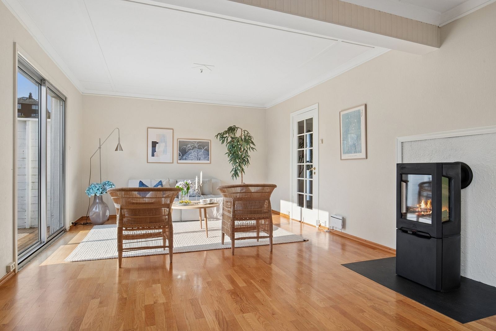 Stue fremstår som lys og trivelig med gode vindusflater som slipper inn godt med naturlig lys som sammen med vedovnen er med på å skape en god atmosfære i rommet Galleribilde