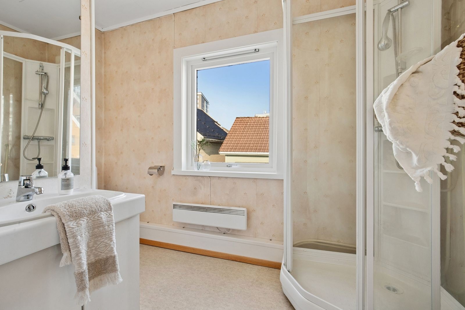 Boligens bad, innredet med dusjhjørne, wc og baderomsinnredning i hvit utførelse. Galleribilde