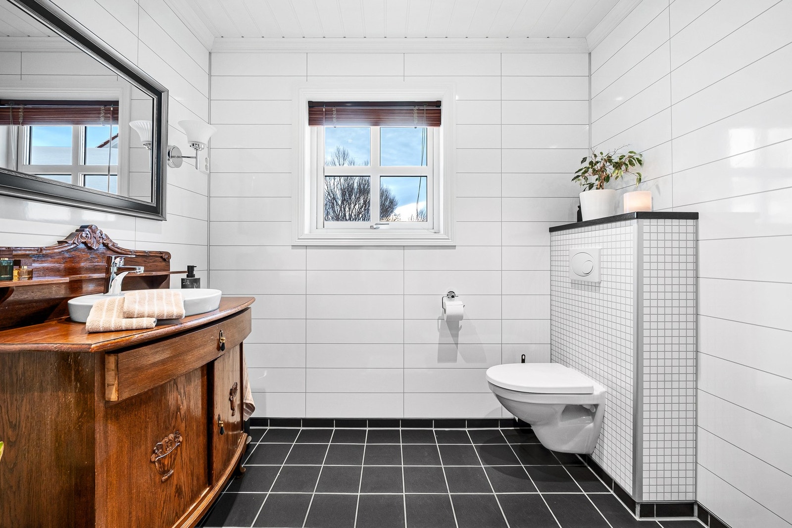 Stilrent bad med flislagt gulv og elektriske varmekabler. Vegghengt WC. Galleribilde