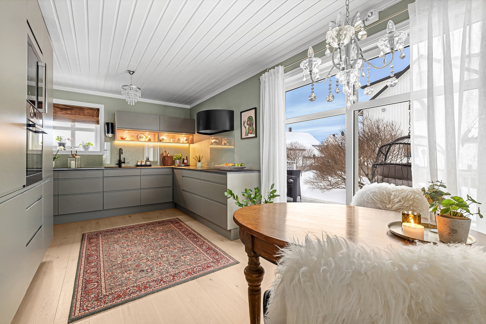 Kjøkkenet var nytt i 2022, og ligger i eget rom. Tidsriktige, glatte fronter og benkeplate i laminat. Galleribilde