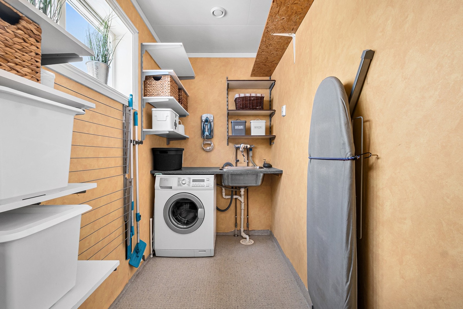 Praktisk bod/vaskerom tilliggende gang. Innredning med diverse oppbevaring, opplegg for vaskemaskin og utslagsvask. Galleribilde