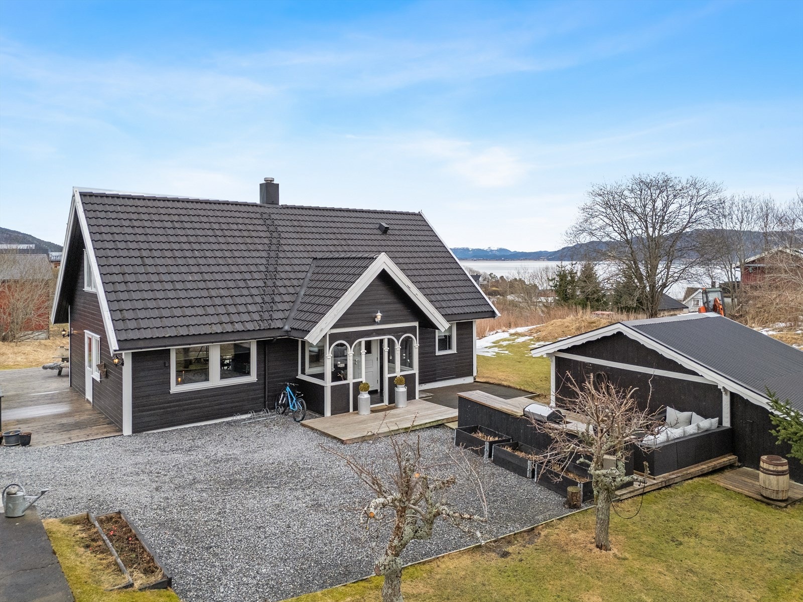 Pent opparbeidet tomt med flere uteplasser på baksisen av huset. Galleribilde