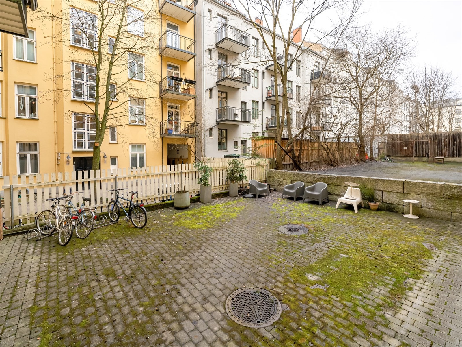 Tomten er pent opparbeidet med steinbelagt bakgård, sykkelstativ, og sittegrupper for beboerene. Galleribilde