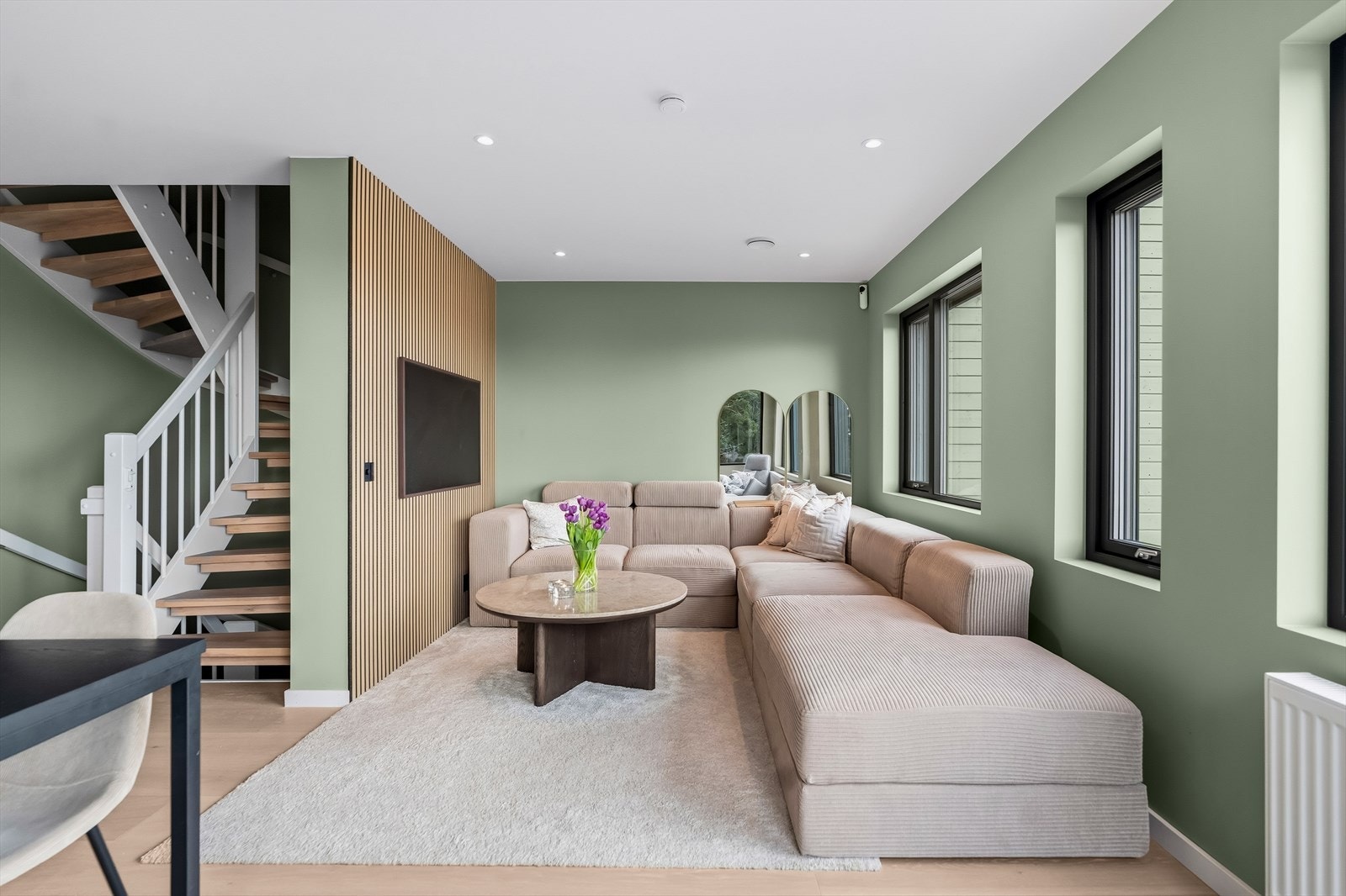 I stuen er det en naturlig sofakrok med fin spilevegg bak TV-en og downlights i himling. Galleribilde