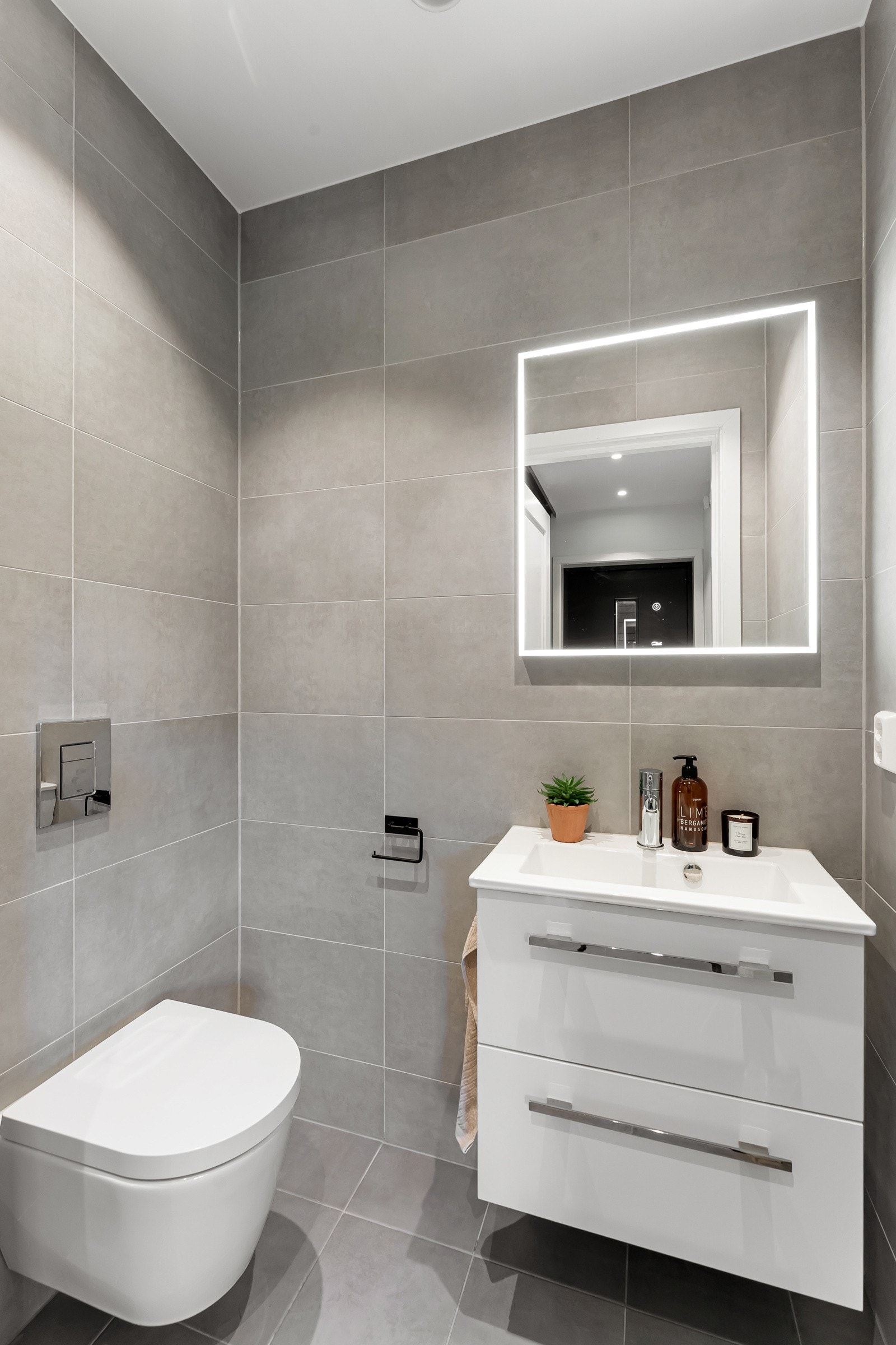 Gjestetoalett i tilknytning til entreen - Utstyrt med vegghengt klosett og heldekkende servant på dobbel skuffeseksjon. Galleribilde