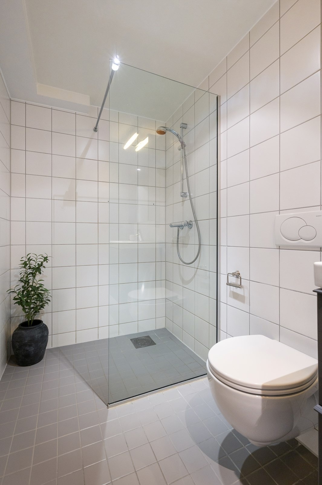 Romslig dusjnisje, varmekabler i gulv og opplegg for både vaskemaskin og tørketrommel Galleribilde