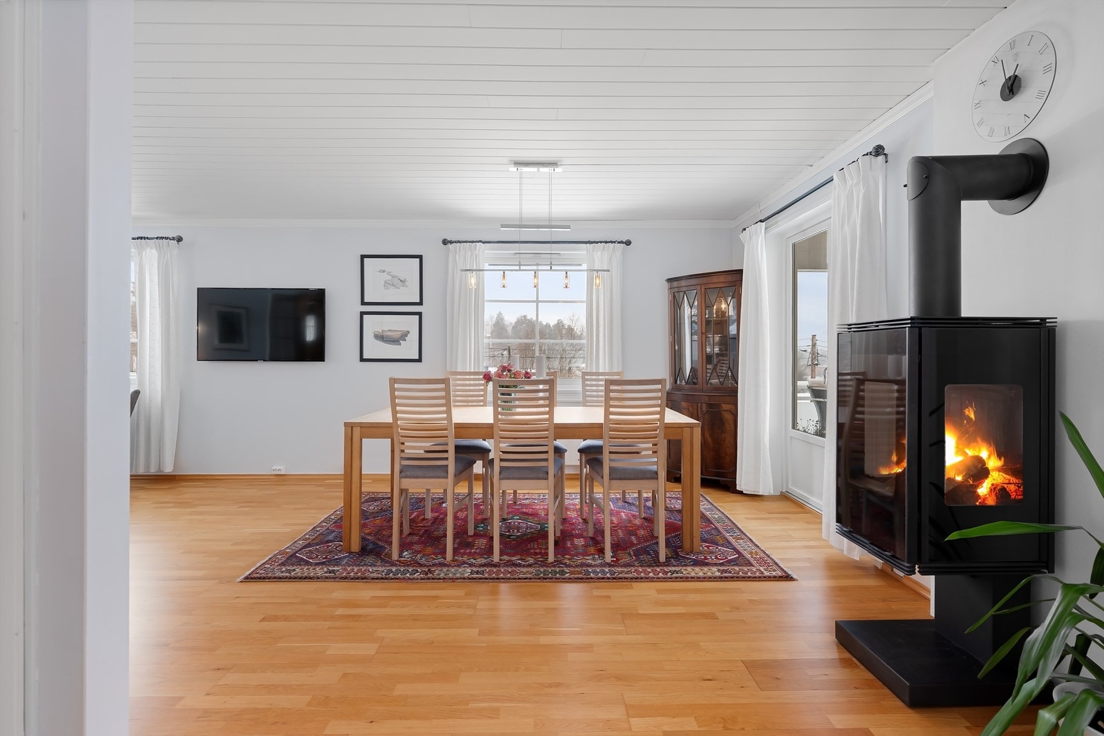 En moderne peisovn fra 2009 gir god varme og en hyggelig atmosfære i stue- og spisestuesonen. Galleribilde