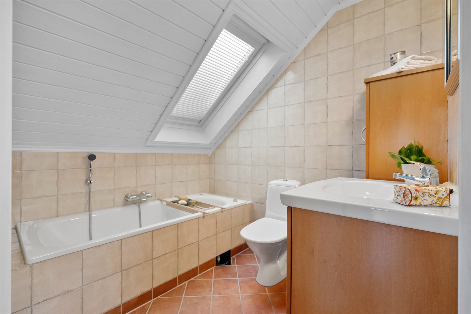 Badet på loftet har flislagt gulv med gulvvarme og et innmurt badekar. Galleribilde