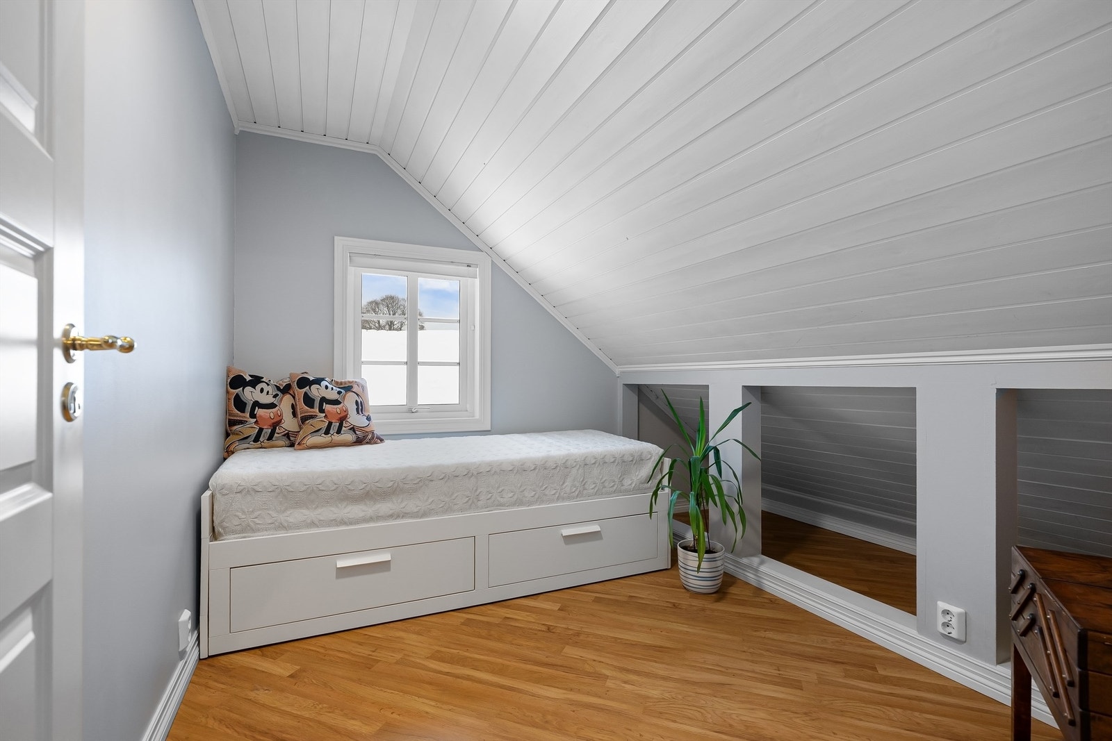 Det andre soverommet på loftet er lyst med malt panel i himlingen. Galleribilde