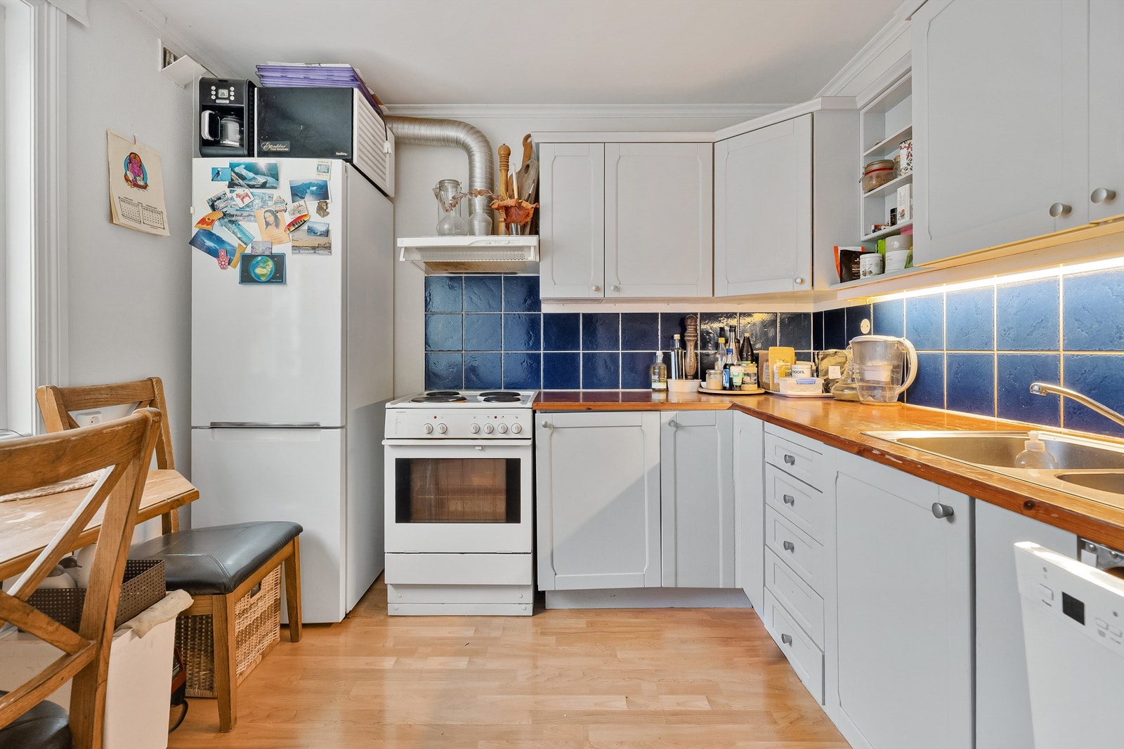 Kjøkkenet i sokkelleiligheten har profilerte fronter, benkeplate i heltre og frittstående hvitevarer. Galleribilde