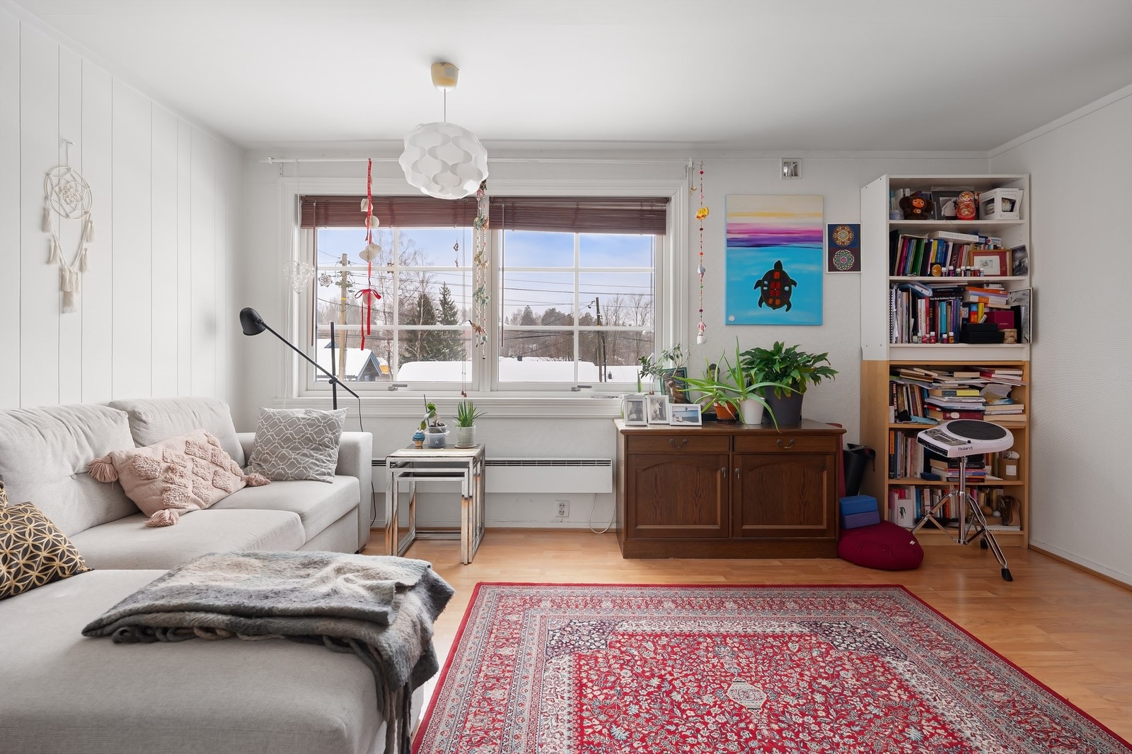 Stuen i sokkelleiligheten har laminat på gulvet og plass til en sofagruppe. Galleribilde