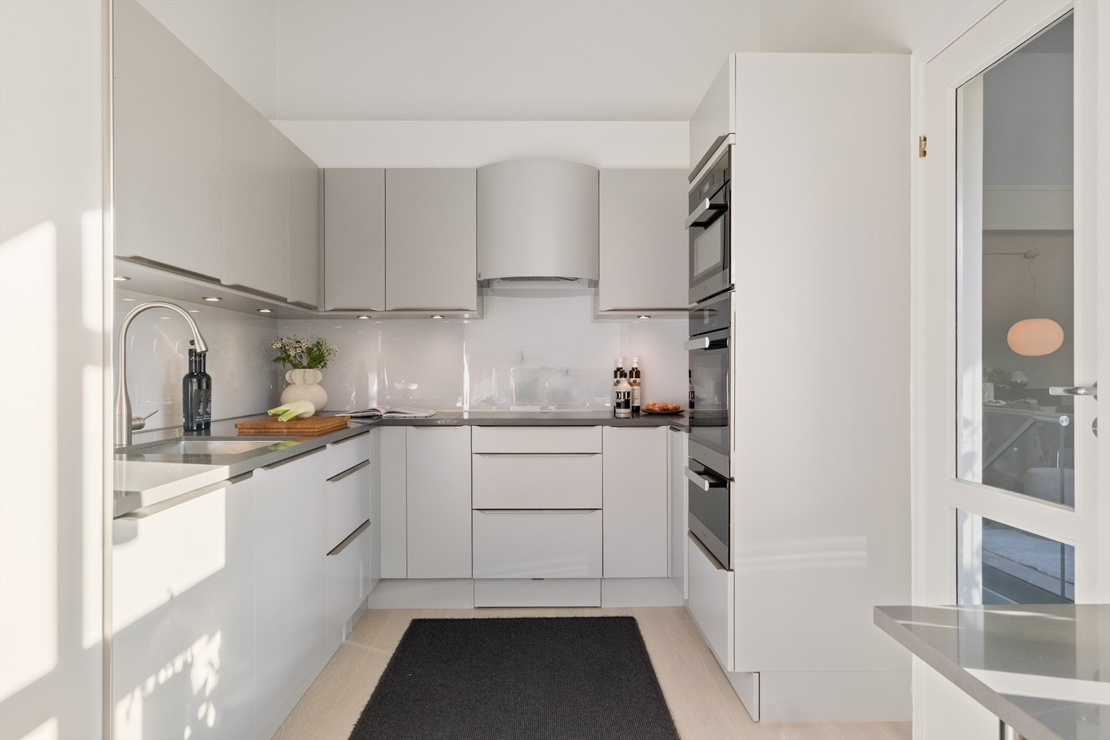 Kjøkkenet har benkeplate i kompositt med nedfelt vask og ett-greps blandebatteri. Her er det rikelig med skap-og benkplass som legger til rette for en god arbeidssone. Galleribilde