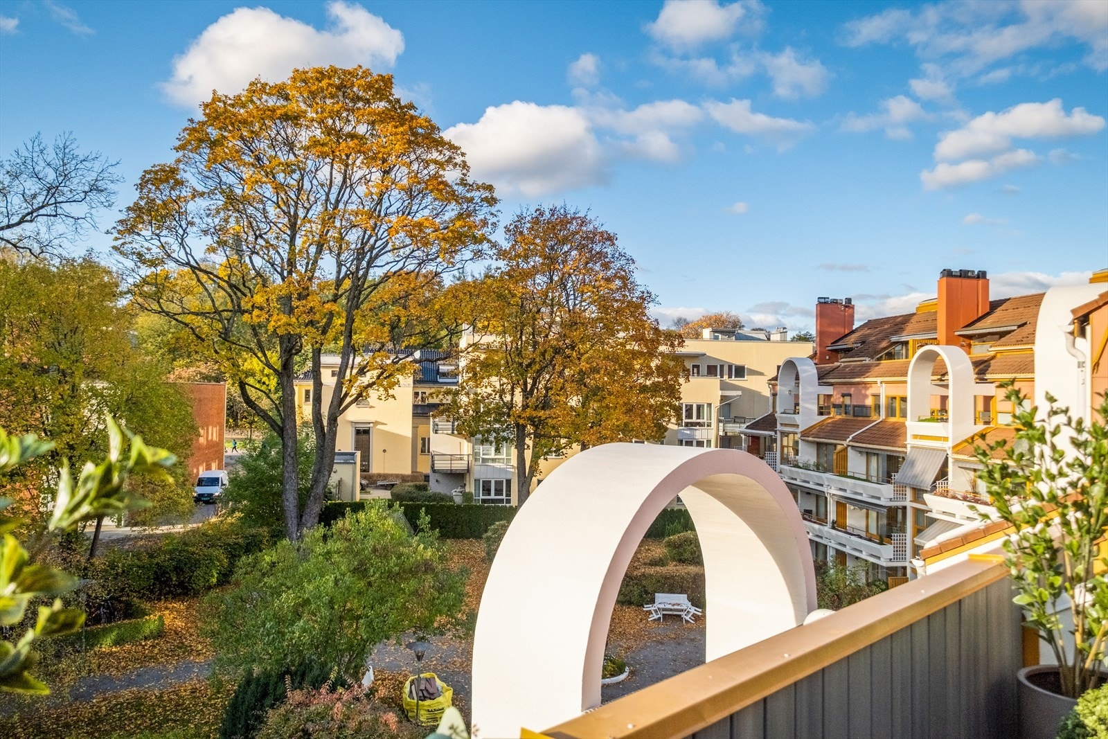 Den private takterrassen er omkranset av frodige trær og utsyn mot sameiets fellesarealer Galleribilde