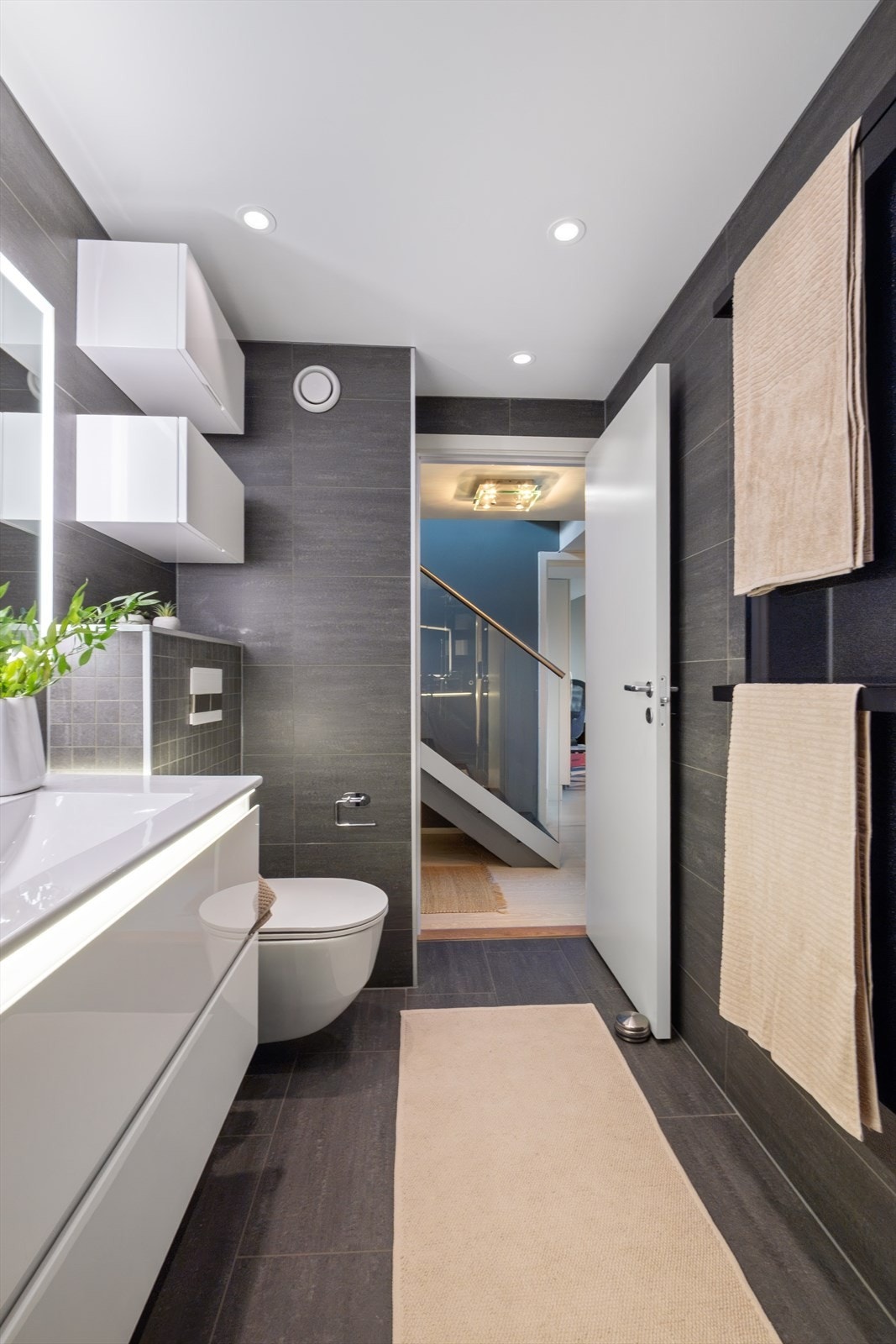 Hovedbadet er innredet med vegghengt toalett, servant med innredning og dusjhjørne med svingbare glassdører. Galleribilde