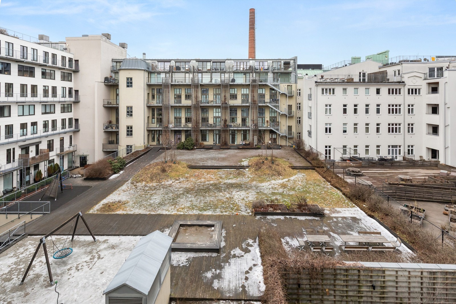 Leilighetens bakgård er pent opparbeidet med lekeapparater og diverse benker og utemøbler. Galleribilde