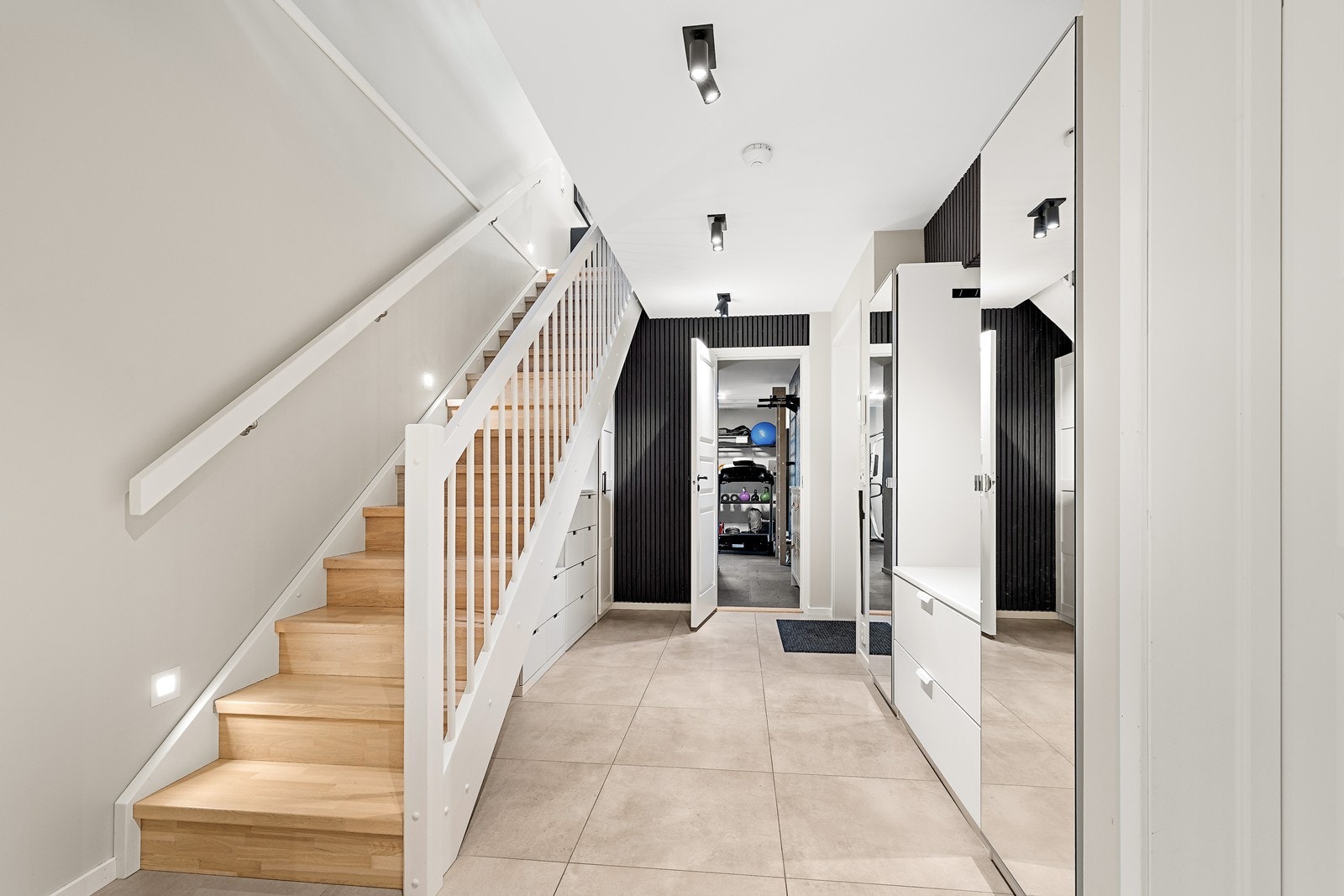 Entréen har en moderne og innbydende stil med oppheng for yttertøy og garderobeløsning. Galleribilde