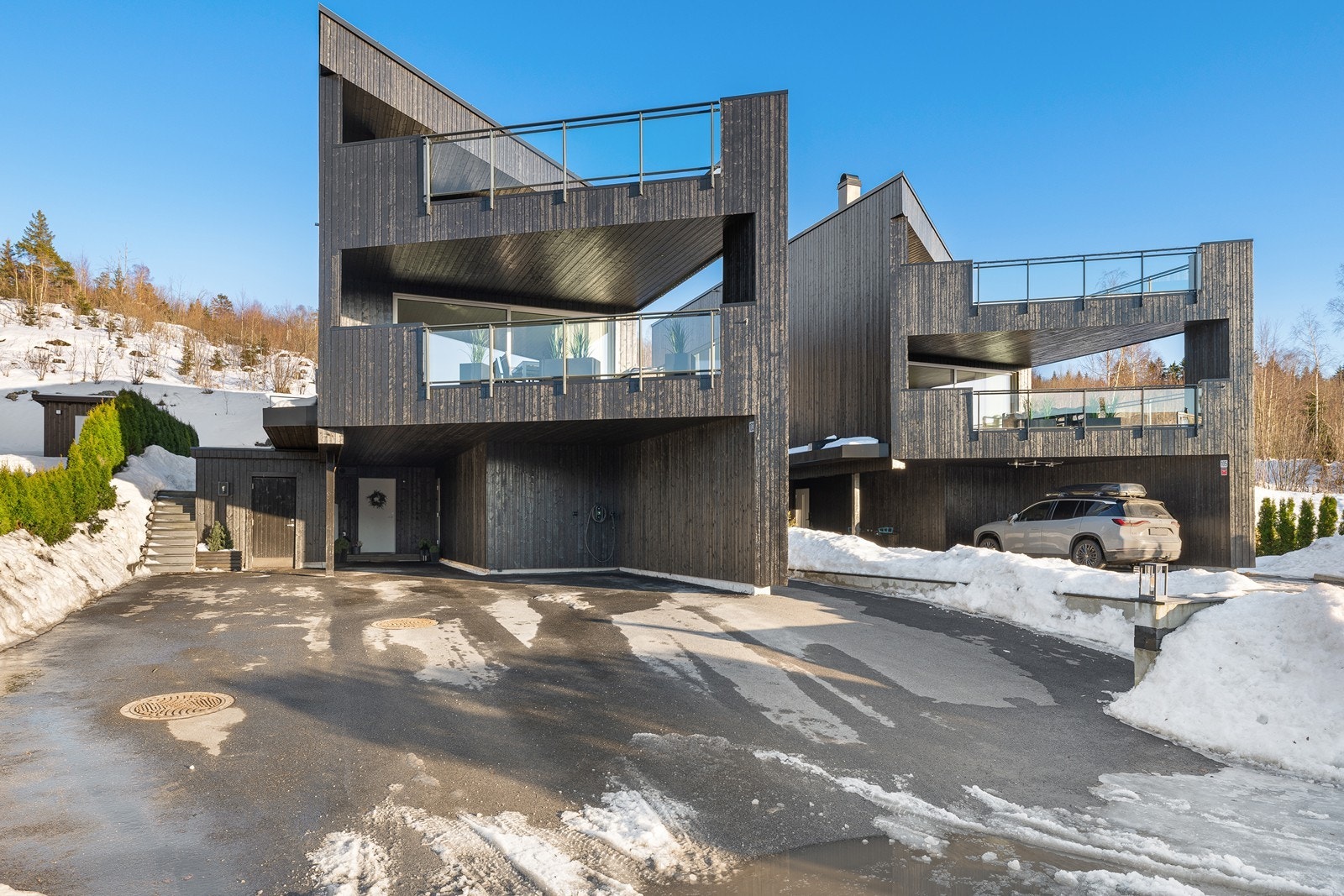 Parkering i asfaltert gårdsplass og under tak. Galleribilde